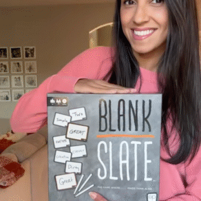 Woman holding the Blank Slate word association game during family game night