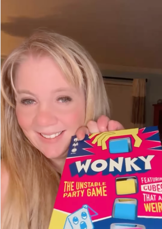 Wonky stacking party game box held during family game night.